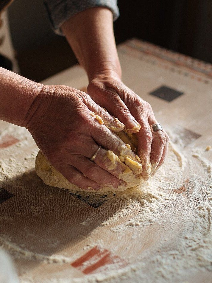 Manos enharinadas trabajando la masa.
