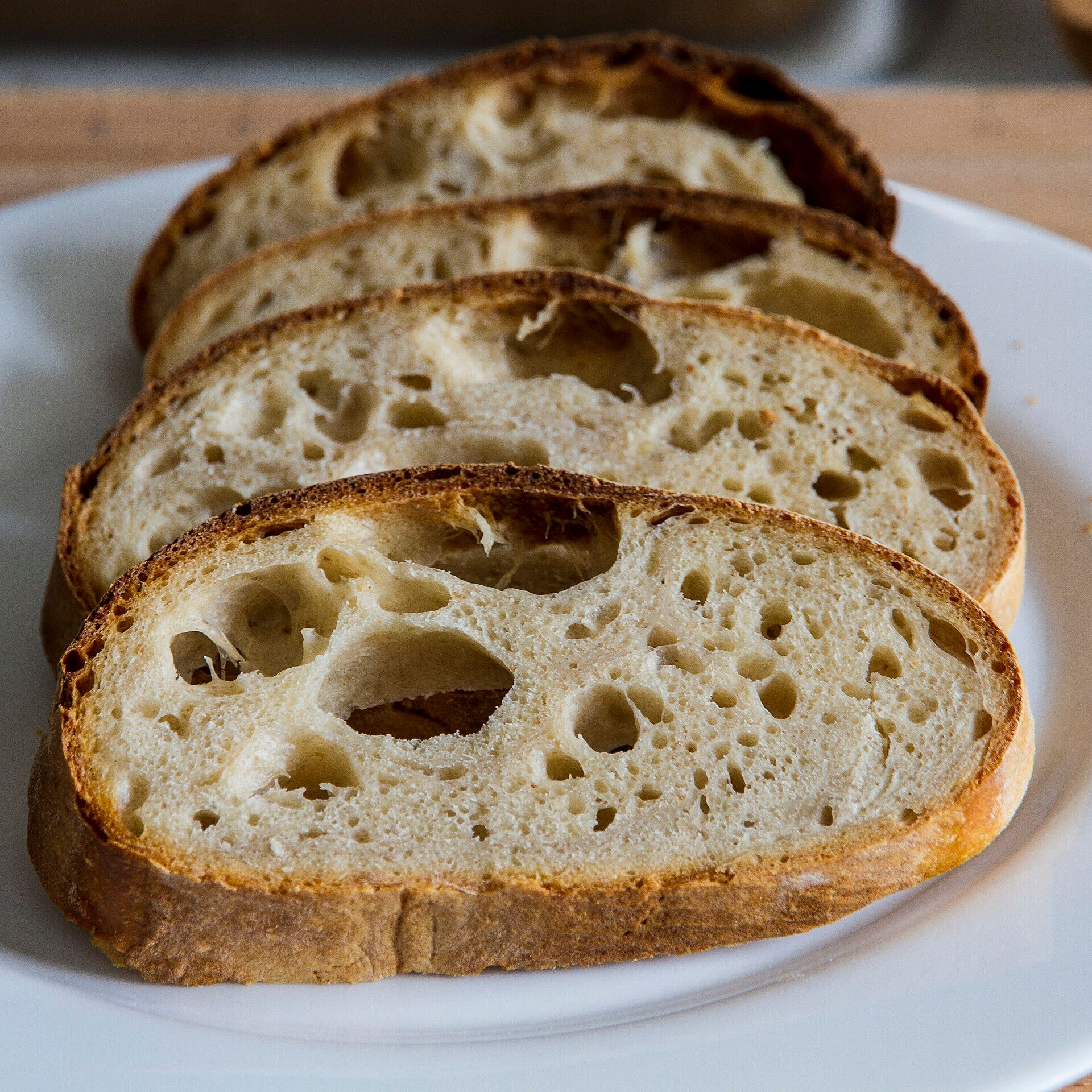 Primer plano de rebanadas de pan de masa madre, con la corteza dorada y la miga abierta.